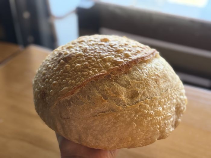 A freshly baked sourdough loaf held in hand