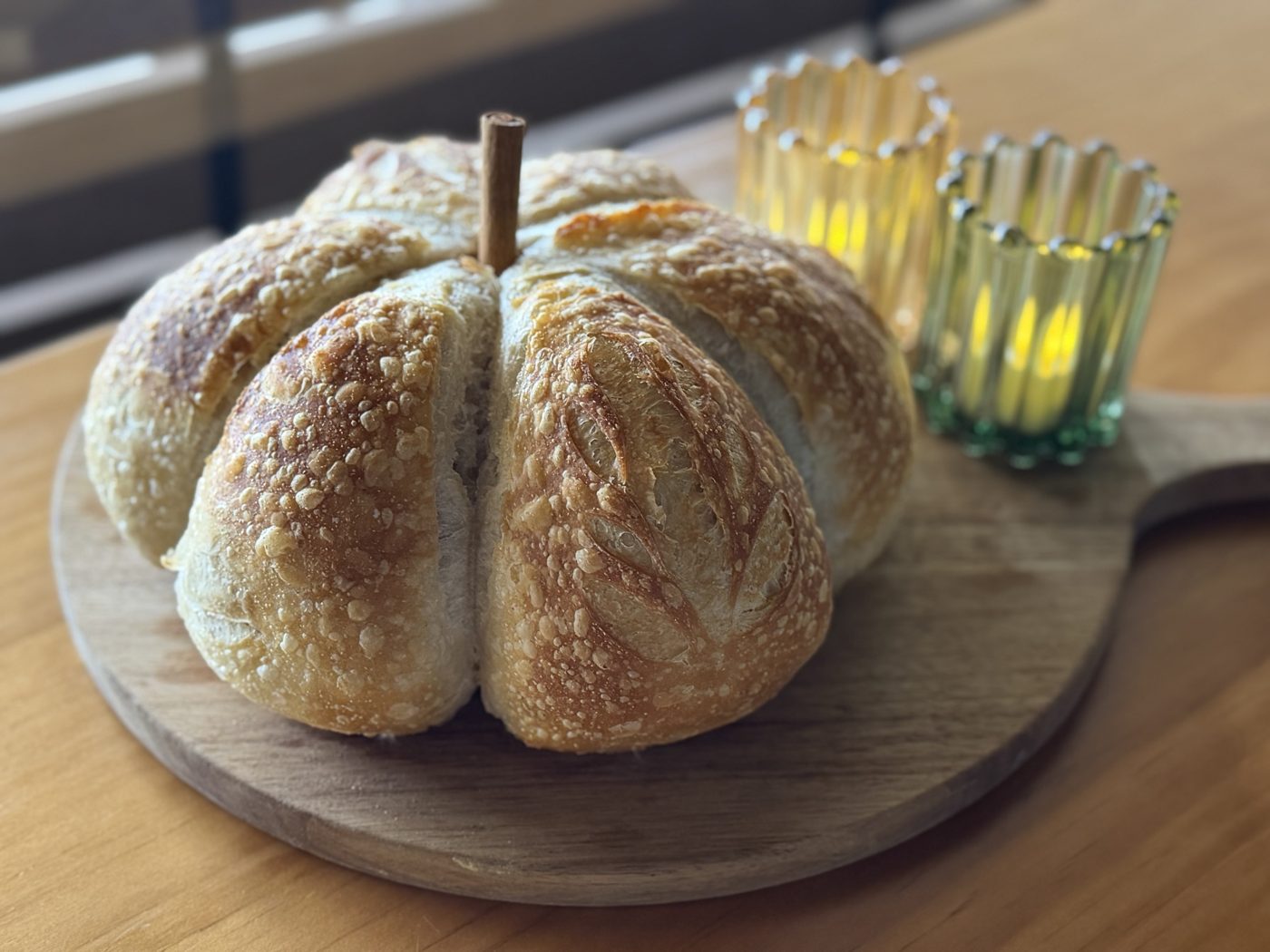 A sourdough loaf shaped like a pumpkin with a cinnamon stick stem